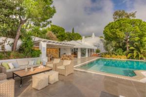 a backyard with a swimming pool and a house at Super Luxury Skiathos Villa - Seven Stunning Bedroom Suites - Villa Daphne - Achliades in Achladies