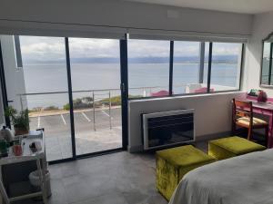 a bedroom with a fireplace and a view of the ocean at 65onCliff in Gansbaai