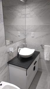 Baño blanco con lavabo y espejo en Amplio departamento Balcon pleno centro Peatonal en Mendoza