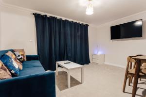 a living room with a blue couch and a table at Modern Peaceful Flat in Town in Bournemouth