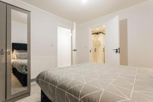 a bedroom with a large bed and a mirror at Modern Peaceful Flat in Town in Bournemouth