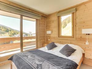 a bedroom with a bed and a large window at Appartement Méribel, 4 pièces, 7 personnes - FR-1-411-511 in Les Allues