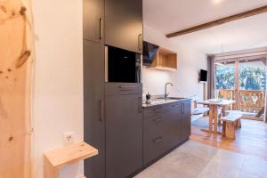 una cucina con grande frigorifero grigio e tavolo di Aschnerhof Holzhitt a Collalbo
