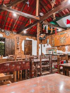 een eetkamer met houten tafels en stoelen bij Pousada Casinha Velha in Macacos