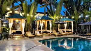 een zwembad met stoelen en parasols naast een resort bij Oceano Boutique Hotel & Gallery in Jacó