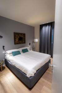 a bedroom with a large white bed with blue pillows at Pasubio Quattro BB in Catania