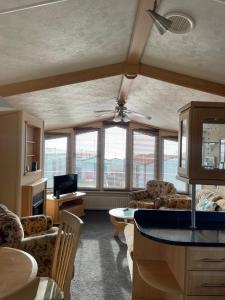 a living room with a couch and a ceiling fan at Immaculate 2-Bed Static Caravan at Monrieth in Newton Stewart