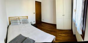 1 dormitorio con 1 cama con sábanas blancas y almohadas azules en Casa Sunta, en Tarzo