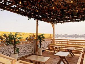 eine Terrasse mit Bänken und Tischen und Blick auf das Wasser in der Unterkunft Awesome 1-Bed-Apt With 24hrs Power & Fast WiFi in Lagos