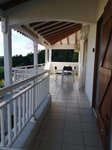 a balcony of a house with a table and chairs at Kaz A Ti Jo in Petit-Bourg