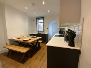 a kitchen with two tables and a counter in a room at Centrally located to the city of Lincoln (Egon) in Lincolnshire