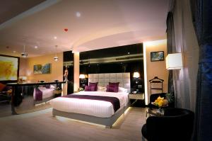 a bedroom with a large bed with purple pillows at Frsan Palace Hotel in Manama