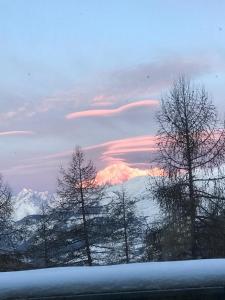 uma vista para uma montanha nevada com árvores e nuvens em Deer Attic em Pila