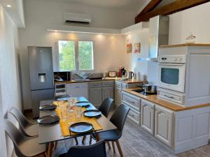 eine Küche mit einem Tisch und Stühlen in der Unterkunft La Remise de Guytou et Spa in Cheval-Blanc