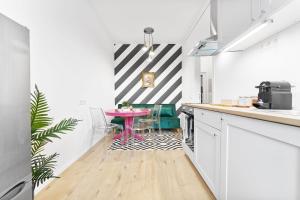 a kitchen with a pink table and a striped wall at Neues modernes Apartment am Theater-zentral mit Privatparkplatz in Cottbus
