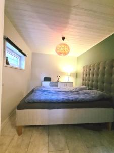 ein Schlafzimmer mit einem großen Bett und einem Kronleuchter in der Unterkunft Tosthult Holiday in Lönsboda