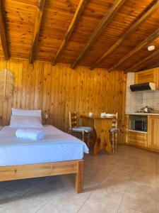 1 dormitorio con 1 cama en una habitación de madera en Villa Maria Koukounaries, en Koukounaries