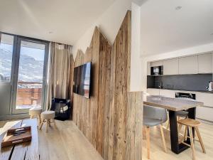 a kitchen with a wooden wall with a table and chairs at Apartment Burons 709-718 by Interhome in Les Menuires +34 photos