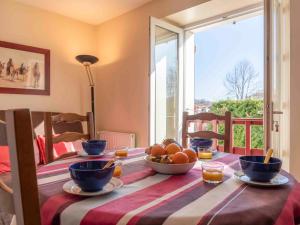 a table with a bowl of fruit on top of it at Apartment Kafartenea by Interhome in Urrugne