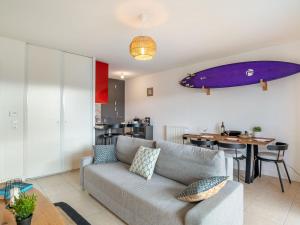 a living room with a couch and a surfboard on the wall at Apartment Xabadenia-4 by Interhome in Bidart