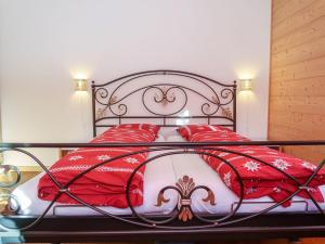 ein Bett mit roten Decken und Kissen darauf in der Unterkunft Apartment Chalet Molignon by Interhome in Haudères