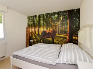 una camera da letto con un cervo nel murale della foresta di Holiday Home Anna by Interhome a Heidersbach