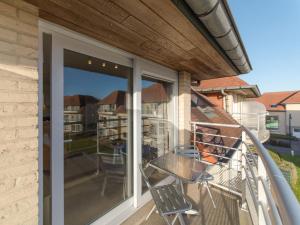 a balcony with sliding glass doors with a table and chairs at Apartment Green Garden-6 by Interhome in De Haan