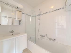 a white bathroom with a shower and a sink at Apartment Green Garden-6 by Interhome in De Haan