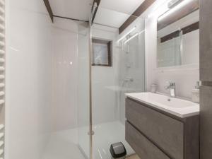 uma casa de banho branca com um chuveiro e um lavatório. em Holiday Home Zeepark Zeepolder-7 by Interhome em De Haan