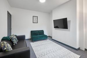 a living room with a couch and a green chair at Host & Stay - Alma in Manchester