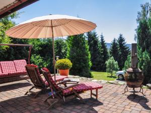 a patio with a table and an umbrella and chairs at Chalet Alwin by Interhome in Heidersbach