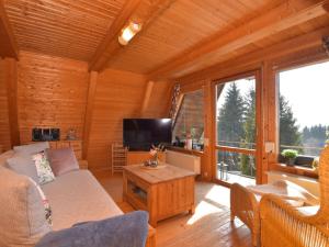 a living room with a couch and a tv at Chalet Alwin by Interhome in Heidersbach