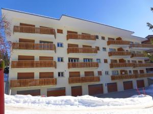 ein großes Gebäude mit Schnee davor in der Unterkunft Apartment Clavan by Interhome in Crans-Montana