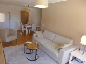 ein Wohnzimmer mit einem weißen Sofa und einem Tisch in der Unterkunft Apartment Clavan by Interhome in Crans-Montana