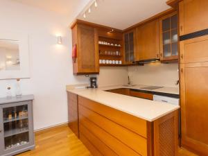 uma cozinha com armários de madeira e uma bancada em Apartment Port Vilanova by Interhome em Vilanova i la Geltrú