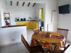 a dining room with a table and a kitchen at Kaz A Ti Jo in Petit-Bourg