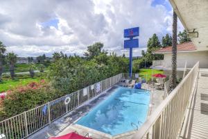 a balcony with a swimming pool and a basketball hoop at Motel 6-Chino, CA - Los Angeles Area in Chino