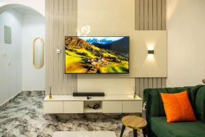 salon z zieloną kanapą i telewizorem na ścianie w obiekcie Adorable 1-Bedroom-Apt With 24hrs Electricity & Unlimited Internet w mieście Lagos