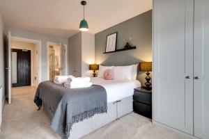 een slaapkamer met een groot bed met witte kussens bij Cozy Camberwell Flat in Londen