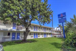 a building with a tree in front of a building at Motel 6-Chino, CA - Los Angeles Area in Chino