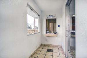 a hallway with a bathroom with a window and a mirror at Motel 6-Chino, CA - Los Angeles Area in Chino