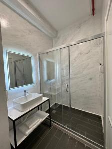 a bathroom with a sink and a shower at ApartHotel Folé in Tirana