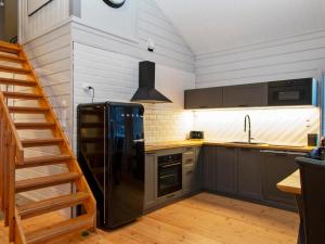 une cuisine avec un réfrigérateur noir et un escalier dans l'établissement Holiday Home Villa milla by Interhome, à Tahkovuori