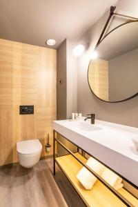 a bathroom with a sink and a toilet and a mirror at Expo Hotel Barcelona in Barcelona