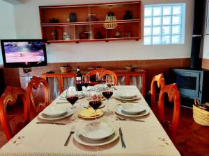 una mesa con platos y copas de vino. en La Casa del Naturalista, en El Bosque