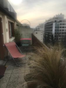una sedia rossa e un tavolo sul balcone di Grand appartement avec terrasse, Paris12 a Parigi