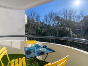 stół na balkonie z żółtymi krzesłami w obiekcie Apartment Feodorowka-2 by Interhome w Arcachon
