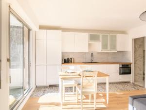 kuchnia z białymi szafkami, stołem i krzesłami w obiekcie Apartment Feodorowka-2 by Interhome w Arcachon +17 zdjęć
