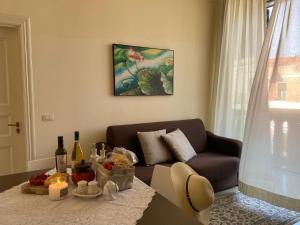soggiorno con divano e tavolo con bottiglie di vino di Palazzo Mongiò a Gallipoli