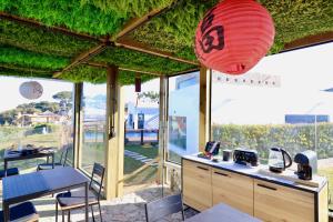 a room with a table and chairs and a red lantern at BeGuest SunRoca Suites in Colares